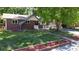 Inviting brick home featuring a lush green lawn and classic architectural details at 8438 Ames St, Arvada, CO 80003