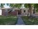 Classic brick home with a neat lawn and inviting walkway, enhanced by a mature tree at 8438 Ames St, Arvada, CO 80003