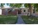 Charming brick home with a well-maintained lawn and inviting walkway at 8438 Ames St, Arvada, CO 80003