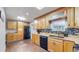 Bright kitchen features wood cabinets, a stylish backsplash, stainless steel appliances and a skylight at 8438 Ames St, Arvada, CO 80003