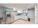 Basement kitchen with white cabinets, stainless steel refrigerator and light wood flooring at 8438 Ames St, Arvada, CO 80003