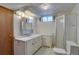 Bathroom with white sink vanity, large mirror, and shower with glass doors at 9584 W Kentucky Ave, Lakewood, CO 80226