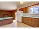 Retro kitchen featuring wooden cabinets, a vintage refrigerator, and a bright countertop at 9584 W Kentucky Ave, Lakewood, CO 80226