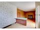 Open living area with brick fireplace, paneled walls, and vintage decor elements at 9584 W Kentucky Ave, Lakewood, CO 80226