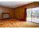 Living area with brick fireplace, wood paneling, and a sliding glass door to the outside at 9584 W Kentucky Ave, Lakewood, CO 80226