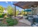 Backyard oasis with a stone fire pit, patio seating under pergola, and manicured landscaping at 6616 Amur Ln, Castle Rock, CO 80108