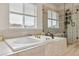 Spa-like bathroom with a soaking tub, glass shower, and large window at 6616 Amur Ln, Castle Rock, CO 80108