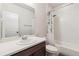 Bright bathroom featuring a tub with white tile surround, a shower with decorative curtains, and a single sink vanity at 6616 Amur Ln, Castle Rock, CO 80108