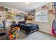 A bedroom with carpet and decorated with posters, a dark bed, and a comfortable colorful chair at 6616 Amur Ln, Castle Rock, CO 80108