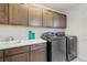 Well-equipped laundry room with modern washer and dryer units and ample cabinet space at 6616 Amur Ln, Castle Rock, CO 80108