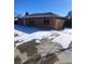 Ranch style home with a large yard and driveway, partially covered in snow at 1240 Russell Blvd, Thornton, CO 80229