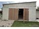 Large garage with wide wooden doors, gravel and grass entrance at 7115 Harold St # 2, Fort Lupton, CO 80621