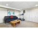 Finished basement featuring a large black sofa, treadmill, closet, and a center table creating a cozy area at 452 Gordon Dr, Castle Rock, CO 80104