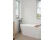 Modern bathroom features a standalone tub with floor mounted faucet between two large windows for great natural light at 716 S Race St, Denver, CO 80209