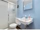 Bathroom with walk-in shower, white toilet and sink, light blue walls, and mirrored medicine cabinet at 258 S 14Th Ave, Brighton, CO 80601