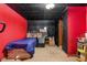 View of furnished room with red walls, black ceiling, twin bed, and various storage boxes at 258 S 14Th Ave, Brighton, CO 80601