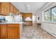 Bright kitchen featuring wood cabinets, white appliances, and a large window at 258 S 14Th Ave, Brighton, CO 80601