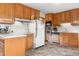Bright kitchen features wood cabinets, white appliances, and tile backsplash at 258 S 14Th Ave, Brighton, CO 80601