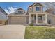 Inviting two-story house featuring a brick facade, front porch, and a double garage at 4037 S Odessa Cir, Aurora, CO 80013