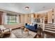 Open living room features a modern blue sofa and a view of the kitchen, creating a cozy and inviting atmosphere at 4037 S Odessa Cir, Aurora, CO 80013