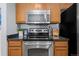 Close up of the stainless steel oven and range in the kitchen with oak cabinetry at 4451 S Ammons St # 4-203, Littleton, CO 80123