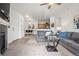 Open living area with a gray couch, carpet, fireplace, and view into the kitchen with bar seating at 4451 S Ammons St # 4-203, Littleton, CO 80123