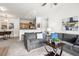 Cozy living room with gray sofas, carpet, adjacent to a kitchen with bar seating and pendant lighting at 4451 S Ammons St # 4-203, Littleton, CO 80123