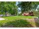 Wide view of a grassy backyard with a home featuring a red deck and a detached garage at 10841 Montview Blvd, Aurora, CO 80010