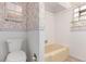 Cozy bathroom with floral wallpaper, a cream-colored bathtub and glass block window adding natural light at 10841 Montview Blvd, Aurora, CO 80010