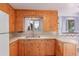 Functional kitchen featuring wooden cabinets, a double sink, and a bright window view at 10841 Montview Blvd, Aurora, CO 80010