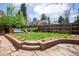 Landscaped backyard with a hot tub, lounge chairs, and a stone patio with brick retaining wall at 350 Albion St, Denver, CO 80220