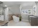 Bathroom with a standalone tub, stylish vanity, herringbone tile accent wall, and bright window at 350 Albion St, Denver, CO 80220