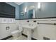Classic bathroom features black and white tiling, pedestal sink, arched mirror, and modern lighting at 350 Albion St, Denver, CO 80220