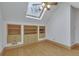 Attic bedroom featuring a vaulted ceiling, skylight, hardwood floors, and built-in shelving at 350 Albion St, Denver, CO 80220
