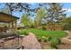 Well maintained back yard features stone pathway, lush lawn, mature trees and shrubs, and covered patio at 7882 S Valentia Way, Centennial, CO 80112