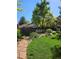 Landscaped backyard featuring a lush lawn, mature trees, and garden beds for outdoor enjoyment at 7882 S Valentia Way, Centennial, CO 80112