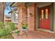 Warm, inviting front entrance featuring a red door, brick details, and a welcome mat at 7882 S Valentia Way, Centennial, CO 80112