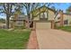 Charming two-story home boasts a manicured lawn, brick accents, and attached two car garage at 7882 S Valentia Way, Centennial, CO 80112