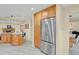 Spacious kitchen showcasing stainless steel refrigerator, tile floors, and maple cabinets at 7882 S Valentia Way, Centennial, CO 80112