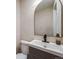 Elegant half bathroom featuring a modern sink with sleek black faucet and a decorative mirror, offering style and functionality at 1103 S Monaco Pkwy, Denver, CO 80224