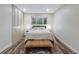 Cozy bedroom with a comfortable bed and a woven bench, providing a serene space with ample natural light from the window at 1103 S Monaco Pkwy, Denver, CO 80224