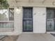 Townhome front porch and entrance feature a secure screen door, painted brick, and modern outdoor lighting at 1103 S Monaco Pkwy, Denver, CO 80224