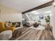 Open living room with exposed beam, fireplace, staircase, and modern decor at 1103 S Monaco Pkwy, Denver, CO 80224