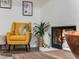 Cozy living room showcasing a charming yellow chair, decorative fireplace, and stylish decor at 1103 S Monaco Pkwy, Denver, CO 80224