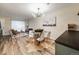 Open concept room offers modern dining with stylish chandelier, wood floors, and comfortable seating area at 1103 S Monaco Pkwy, Denver, CO 80224