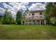 Expansive backyard with a large deck, lush green lawn, and mature trees at 19735 Knights Xing, Monument, CO 80132
