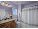 Light-filled bathroom featuring a granite vanity, decorative shower curtain, and a window with a view at 19735 Knights Xing, Monument, CO 80132