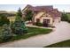 Beautiful exterior elevation with a well manicured lawn, mature trees and a long driveway at 19735 Knights Xing, Monument, CO 80132