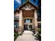 Grand front entrance featuring an impressive porch, stone pillars, and beautiful landscaping at 19735 Knights Xing, Monument, CO 80132