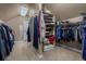 Spacious walk-in closet featuring custom shelving, hanging racks, and carpeted floors providing ample storage at 19735 Knights Xing, Monument, CO 80132